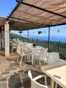 a patio with tables and chairs and a view of the ocean at Villa Filip in Vuno