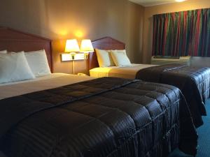 um quarto de hotel com duas camas e duas lâmpadas em Budget Inn - Saint Robert em Saint Robert