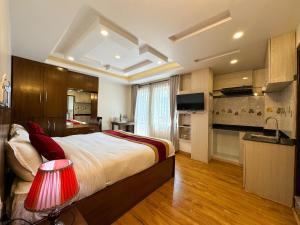 a bedroom with a large bed and a kitchen at Hotel Abi International in Kathmandu