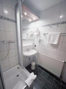 ein Badezimmer mit Dusche, Waschbecken und Badewanne in der Unterkunft Hotel Albers in Recklinghausen