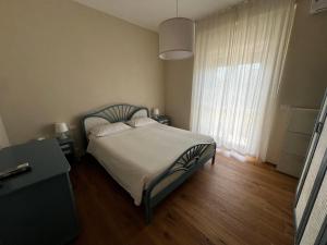 バーリにあるVilla Sissiのベッドと大きな窓のある寝室