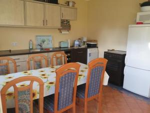 a kitchen with a table and chairs and a white refrigerator at Ferienhaus Retzow in Rechlin