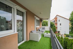 a balcony with a couch and chairs on a balcony at ★ BB Wellness Apartman ★ in Siófok