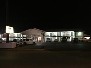 a building with cars parked in a parking lot at night at Budget Inn - Saint Robert in Saint Robert