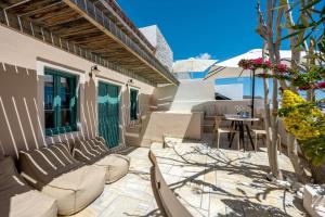 a patio with chairs and a table and an umbrella at Passion Blue Villas in Oia