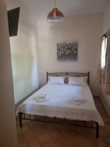 a bedroom with a bed with white sheets and pillows at Studio Καρπώ Karpo in Galaxidhion