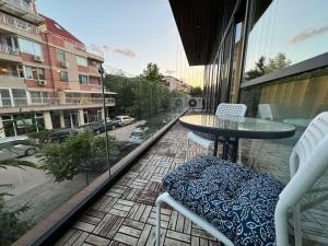 balcón con mesa y sillas y vistas a la calle en Modern Vitosha Maisonette with Garage, en Sofía