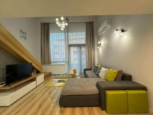 Una sala de estar con un sofá y un televisor. en Modern Vitosha Maisonette with Garage, en Sofía