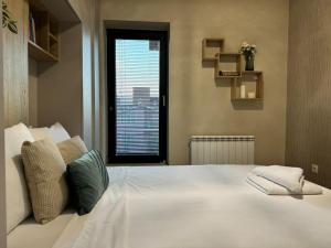 Una cama blanca grande con dos almohadas encima. en Modern Vitosha Maisonette with Garage, en Sofía