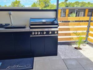 a barbecue grill in a patio with a plant at Mobile home Marina in Drage +29 photos