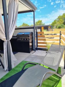 a patio with a grill and a chair at Mobile home Marina in Drage