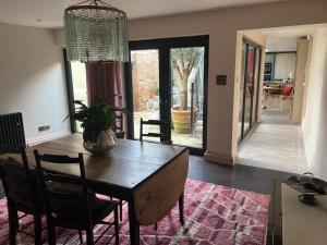 a dining room with a table and chairs and a room with a hallway at Pallant Hideaway in Chichester