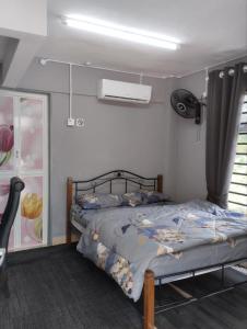 a bedroom with a bed and a window at SH Homestay in Kota Bharu