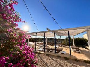een paviljoen op het strand met roze bloemen bij TerreAmare Agriturismo in Porto Cesareo