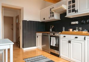 Una cocina con gabinetes blancos y una estufa. en Za Oknem Wierchowa, en Rymanów-Zdrój