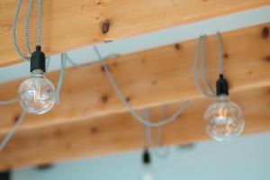 Tres bombillas colgando de un techo de madera en Za Oknem Wierchowa, en Rymanów-Zdrój