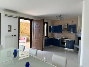 a kitchen with blue cabinets and a table and chairs at Terra Bianca Salento in Nardò