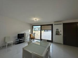 a living room with a glass table and a television at Terra Bianca Salento in Nardò