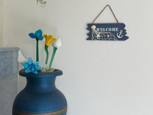 a blue vase with flowers and a sign on a wall at Terra Bianca Salento in Nardò