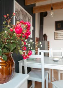 Un jarrón con flores rojas sobre una mesa. en Za Oknem Wierchowa, en Rymanów-Zdrój
