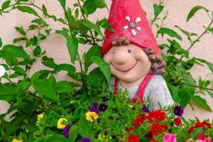a statue of a girl in a pot of flowers at Sonnentau in Sankt Johann im Pongau +2 photos