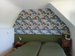 a bedroom with a bed with a floral head board at Maison de vacances Ty Kornog in Pont-Aven