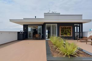 a modern house with a roof at Studio prox shopping Curitiba Wifi, TV a Cabo e ar by UROOMS in Curitiba