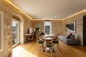 Un comedor con una mesa y un sofá. en Corten House - IsulaTravel, en Módica