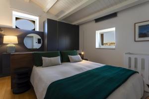 Un dormitorio con una cama grande y un espejo. en Corten House - IsulaTravel, en Módica 30 fotos más