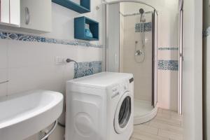 a bathroom with a washing machine and a shower at Porto Ottiolu Resort in Porto Ottiolu