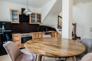 a kitchen with a wooden table and chairs at Dom mazurski z basenem in Rydzewo