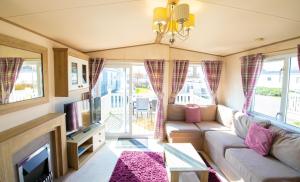 a living room with a couch and a tv at SBL48 Camber Sands Holiday Park in Camber