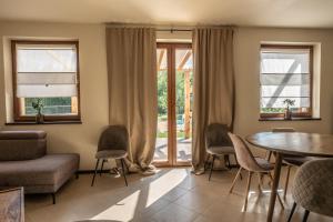 a living room with a table and chairs at Dom mazurski z basenem in Rydzewo +1 photo