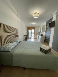 a bedroom with a large bed and a kitchen at House 421 in Rome