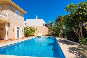 a swimming pool in front of a house at Bayside Concha House - Beachfront Oasis with Heated Pool in Playa Honda