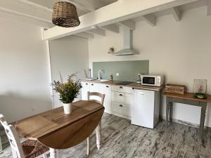 a kitchen with a wooden table and a dining room at La Cabane Lacourrège in Urgosse