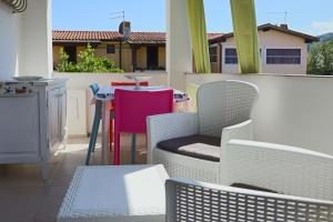 a balcony with white chairs and a table and a table at Porto Ottiolu Resort in Porto Ottiolu