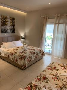 萨索斯luxury studios & apartments Athanasias的一间带床和大窗户的卧室
