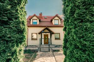 a house seen through two large hedges at Dom mazurski z basenem in Rydzewo