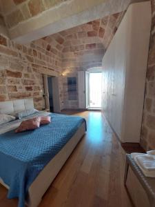 a bedroom with a bed and a stone wall at Brezza Marina in Polignano a Mare