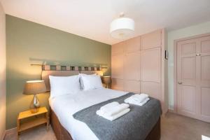una camera da letto con un letto con due asciugamani sopra di Delightful Garden Upper Cottage in Oldhamstocks East Lothian a Oldhamstocks