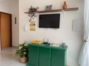 a green cabinet with a flat screen tv on a wall at Vila Girassol in Aracaju +13 photos