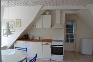 a kitchen with white cabinets and a table and a sink at Ribe Dankirke Bed & Kitchen in Ribe