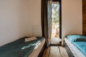 a room with two beds and a table and a window at Domki Marina Rydzewo in Rydzewo