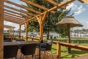 a wooden deck with a table and chairs and an umbrella at Domki Marina Rydzewo in Rydzewo