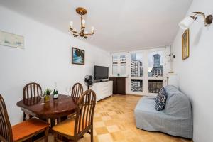 a living room with a table and a dining room at Pereca 2 Rondo ONZ By Perfect Apart 801 in Warsaw +4 photos