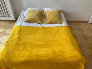 a bed with a yellow blanket on top of it at Pereca 2 Rondo ONZ By Perfect Apart 801 in Warsaw