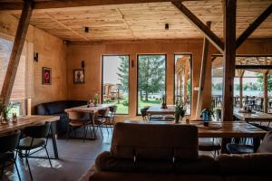 a restaurant with tables and chairs and large windows at Domki Marina Rydzewo in Rydzewo +4 photos