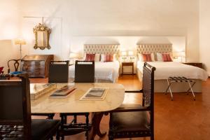 a bedroom with two beds and a table and chairs at Palazzo D'Ambra Residenza d'Epoca in Florence