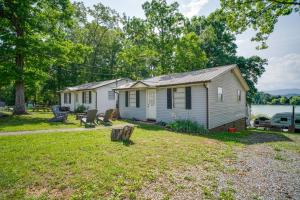 a small white house with a yard at Lakefront Cabin in Dandridge with Fire Pit and Grill! in Dandridge